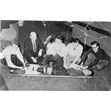 First aid team, Harbord Collegiate, Toronto, [between 1947 and 1948]. Ontario Jewish Archives, Blankenstein Family Heritage Centre, item 739.|Item is a photograph of a young woman laid out on a stretcher while four students and possibly a teacher practice attending to her wounds